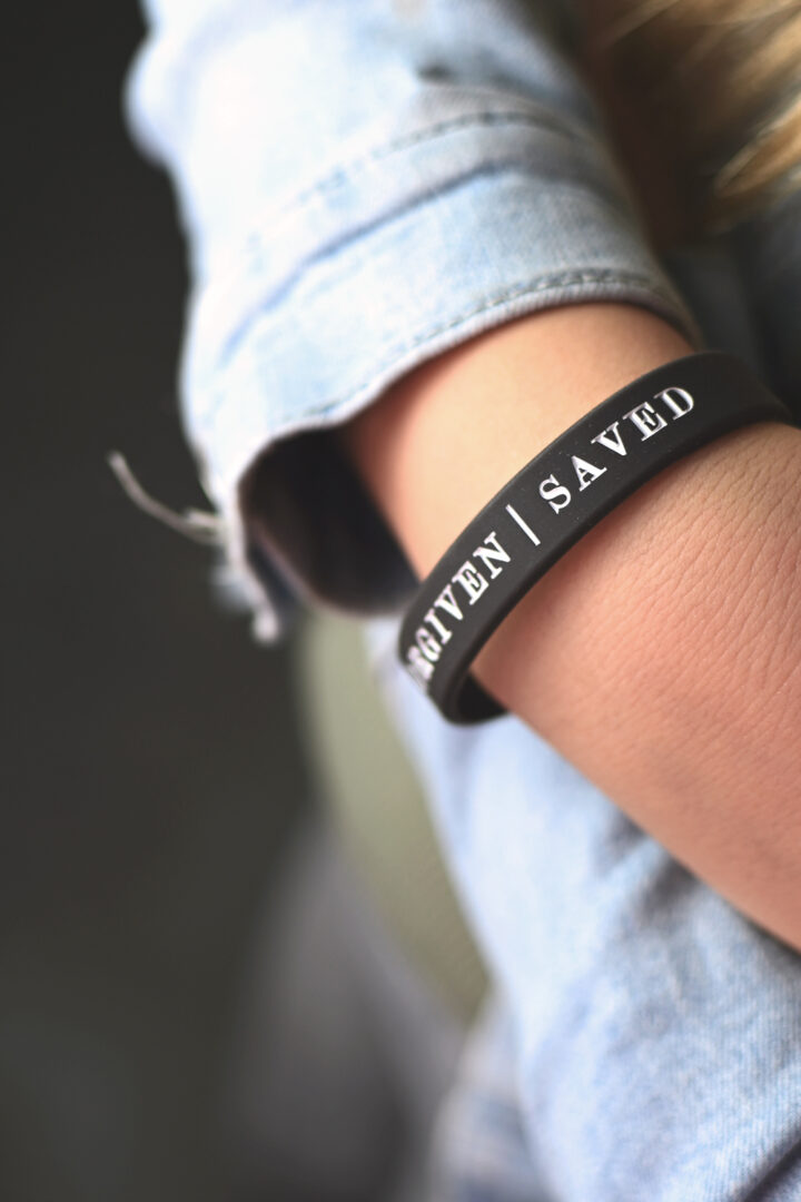 Silikonarmband i mörkgrått: Surrounded, forgiven, saved (tonårsstorlek)